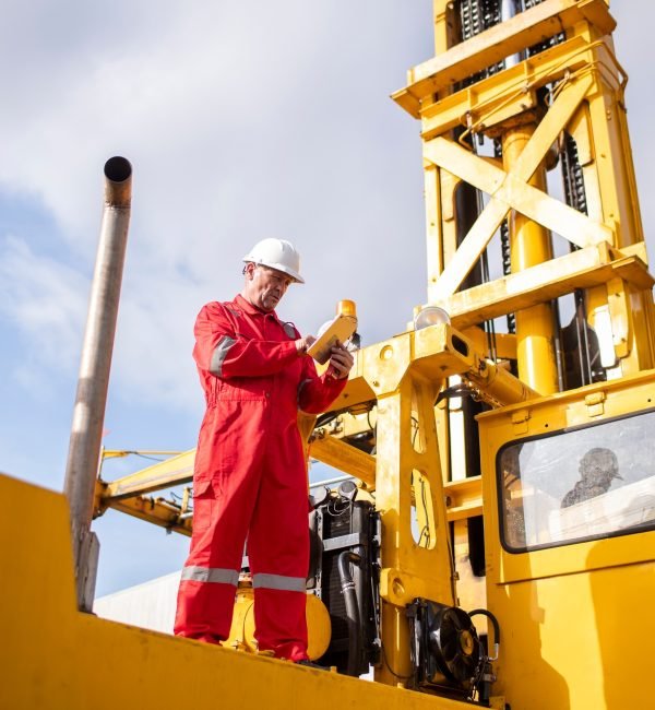 Engineer or worker standing forklift or truck vehicle are holding detail and appear to be discussing