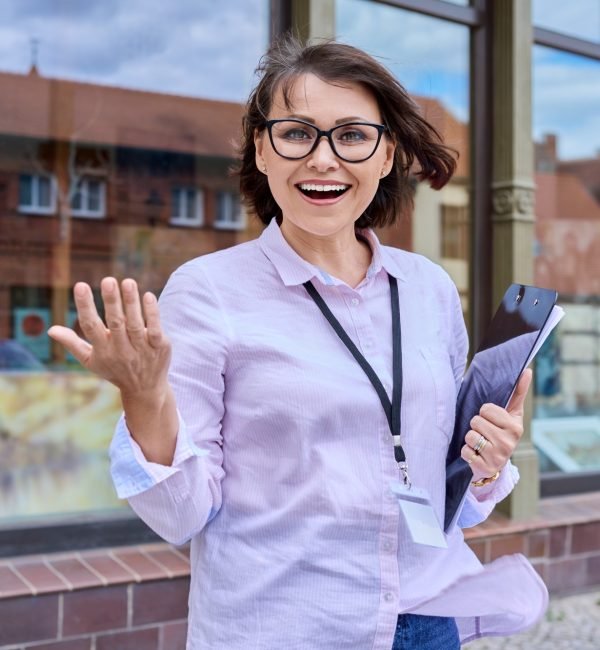 Woman art gallery worker standing near glass showcase of outdoor art store